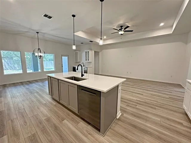 a kitchen with a sink and wooden floor