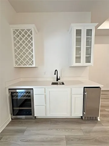 a living room with stainless steel appliances a fireplace and wooden floor