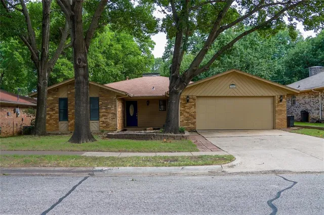 a front view of a house with a garden and trees