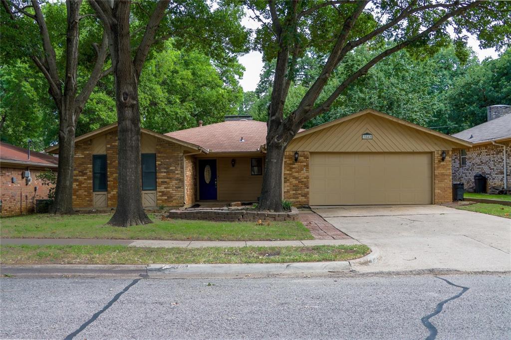 a front view of a house with a garden and trees