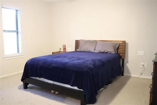 a bed sitting in a bedroom next to a window