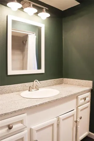 a bathroom with a sink vanity and a mirror