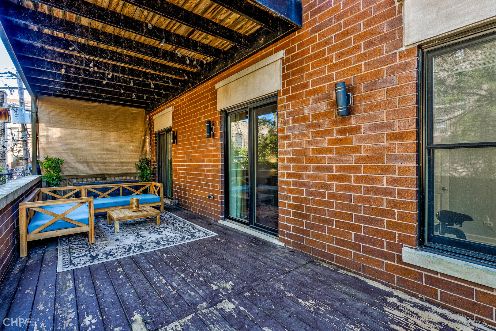 4603 North Racine Avenue, Unit 201 Chicago, IL 60640 - Photo 27 of 33 a view of a balcony with couch and wooden floor