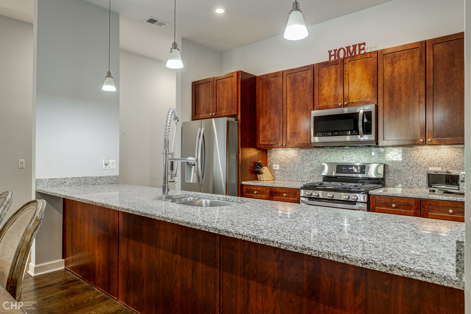 4603 North Racine Avenue, Unit 201 Chicago, IL 60640 - Photo 10 of 33 a kitchen with stainless steel appliances granite countertop a refrigerator a stove a sink dishwasher and wooden cabinets with wooden floor