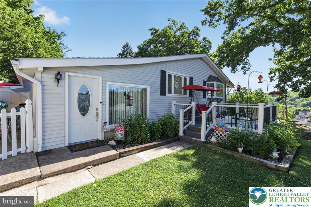 740 Public Road Bethlehem, PA 18015 - Photo 2 of 40 A welcoming front entrance and deck offer serene outdoor living amidst lush greenery.