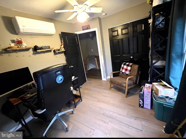 a living room with furniture a flat screen tv and a refrigerator