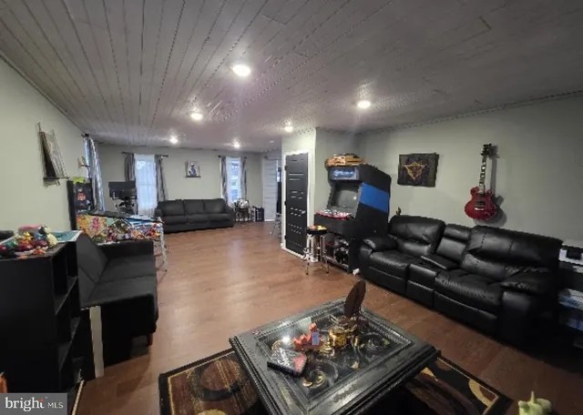 a living room with furniture a flat screen tv and a table