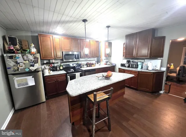 a large kitchen with a table chairs and flat screen tv