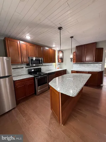 a kitchen with kitchen island a sink appliances and cabinets