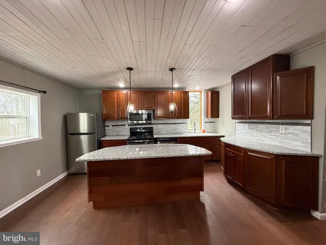 a large kitchen with stainless steel appliances a large counter top
