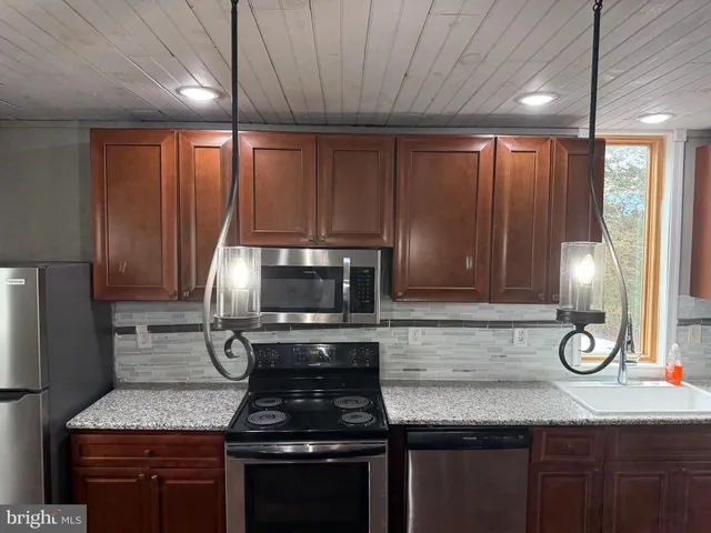 a kitchen with a stove a sink and a microwave