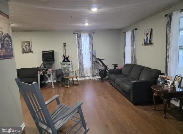 a living room with furniture a wooden floor and a flat screen tv