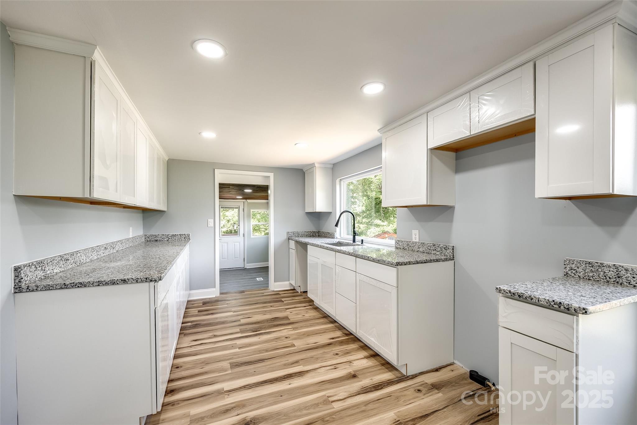 1224 Martin Road Hickory Grove, SC 29717 - Photo 20 of 40 a kitchen with granite countertop white cabinets and white appliances