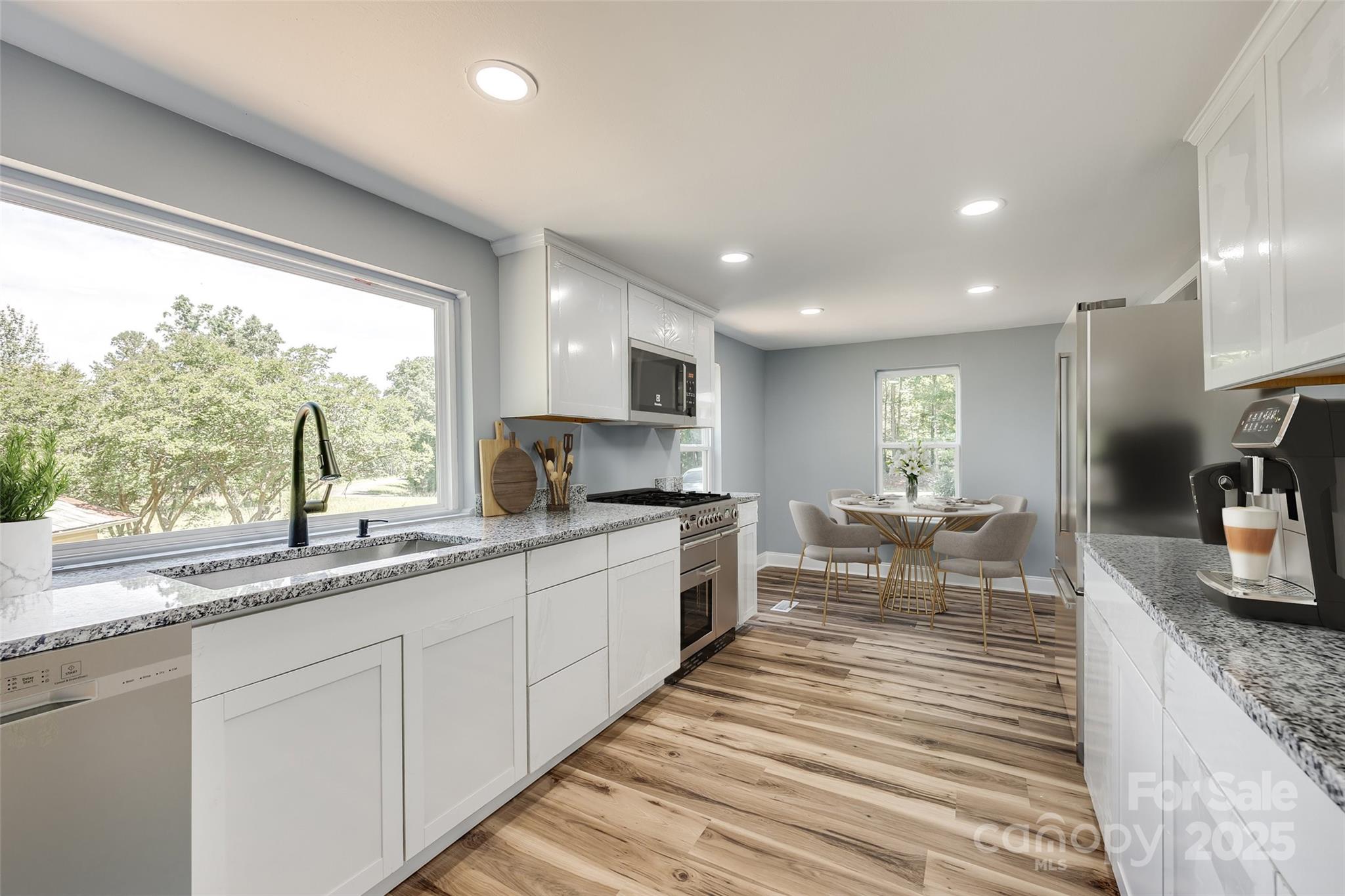 1224 Martin Road Hickory Grove, SC 29717 - Photo 9 of 40 a large kitchen with granite countertop a large window and white cabinets