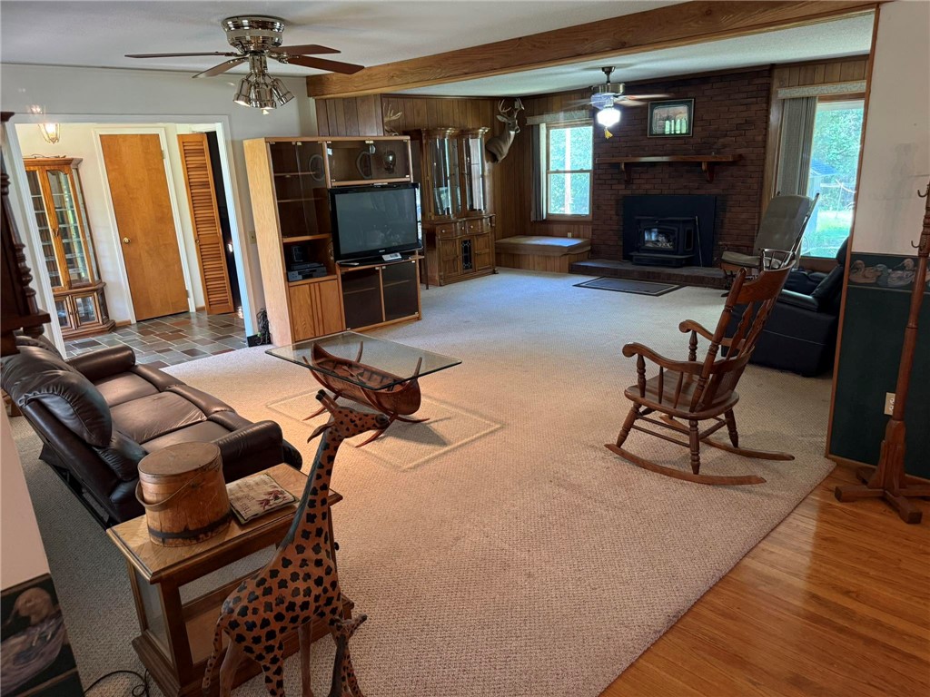 4027 Belhaven Road Belton, SC 29627 - Photo 6 of 24 A welcoming living area boasts a cozy fireplace with brick surround, rich wood accents, and ceiling fans for comfort.