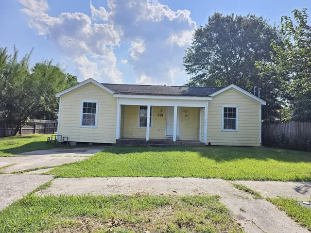 a front view of a house with a garden and yard