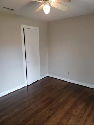an empty room with wooden floor and white walls