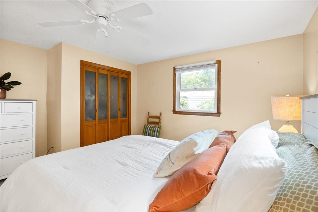 83 Brookside Road Rockland, MA 02370 - Photo 15 of 31 a bedroom with a large bed and a chandelier