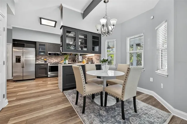 a view of a dining room with furniture a chandelier and wooden floor