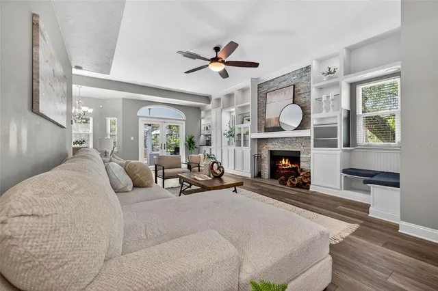 a living room with furniture a fireplace and a large window