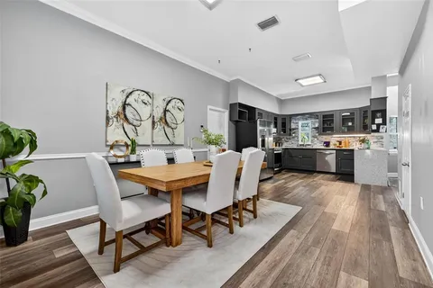 a living room with stainless steel appliances kitchen island granite countertop furniture wooden floor and a kitchen view