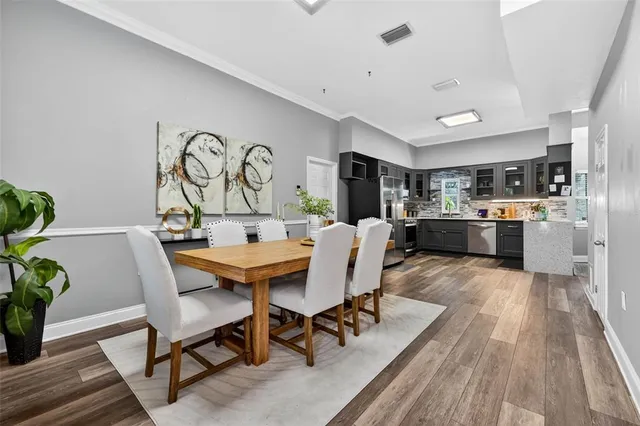 a living room with stainless steel appliances kitchen island granite countertop furniture wooden floor and a kitchen view