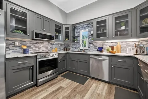 a kitchen with stainless steel appliances kitchen island granite countertop a sink stove and microwave