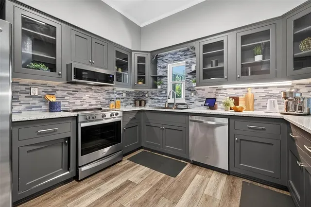 a kitchen with stainless steel appliances kitchen island granite countertop a sink stove and microwave