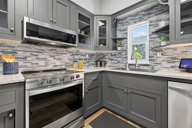 a kitchen with granite countertop a stove microwave and sink