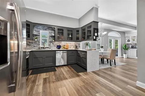 a kitchen with stainless steel appliances granite countertop a sink and wooden cabinets