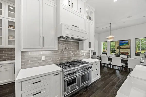 a kitchen with stainless steel appliances white cabinets and wooden floor