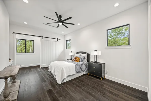 a bedroom with a bed a chandelier and a chair