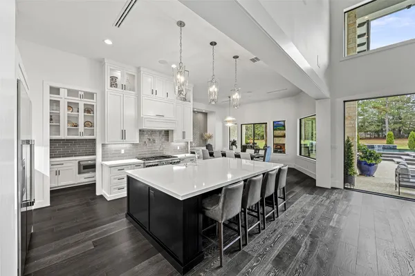 a large kitchen with a counter space a sink appliances and a large window