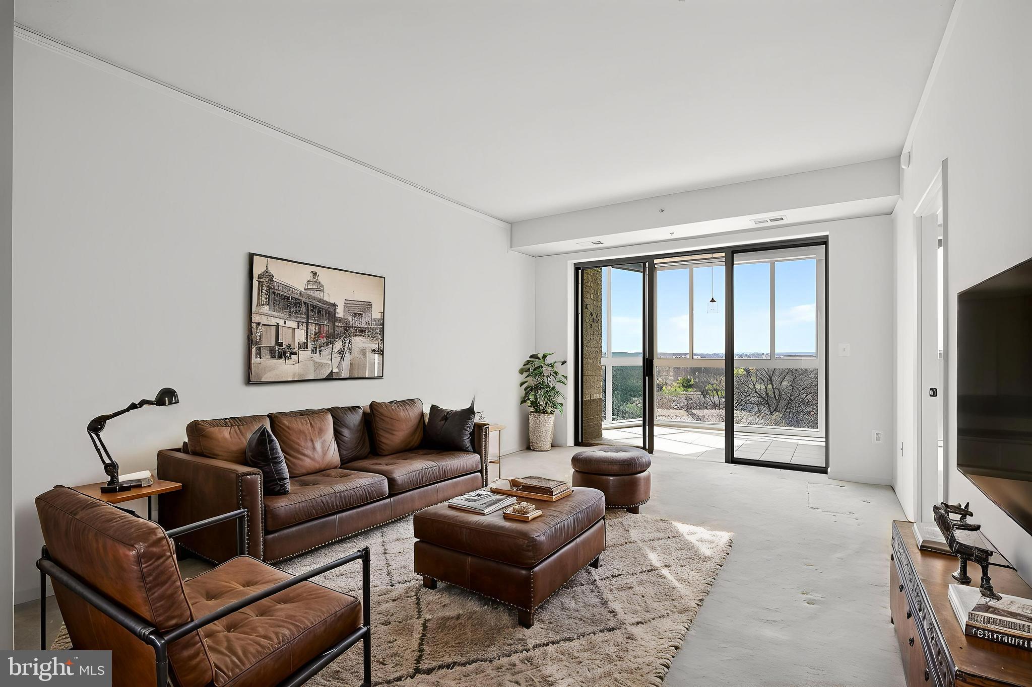 19355 Cypress Ridge Terrace, Unit 1122 Leesburg, VA 20176 - Photo 10 of 71 a living room with furniture a flat screen tv and a floor to ceiling window