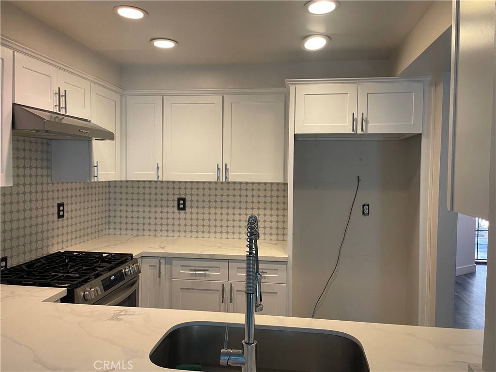 1707 Garvey Avenue, Unit 12 Alhambra, CA 91803 - Photo 8 of 22 a kitchen with kitchen island granite countertop a sink cabinets and stainless steel appliances