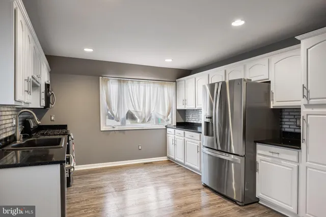 a kitchen with a refrigerator sink and stove top oven