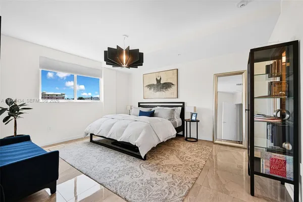 a bedroom with a large bed and a chandelier