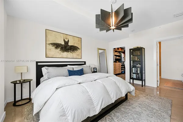 a bedroom with a bed a mirror and dresser