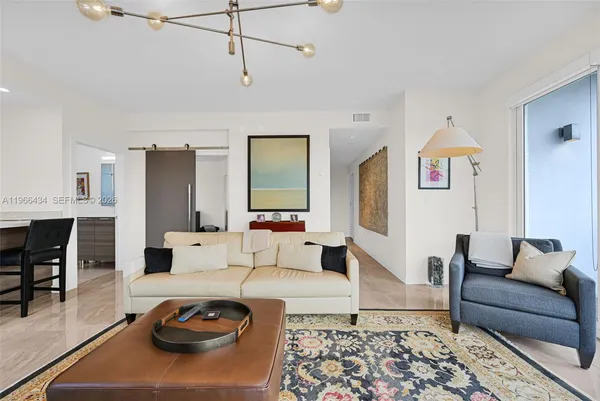 a living room with furniture a large window and dining table