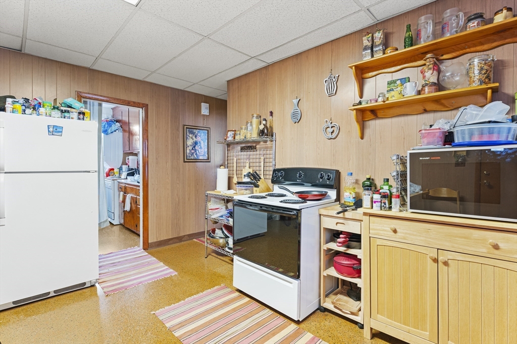 15 Sturgis Street Woburn, MA 01801 - Photo 30 of 38 a kitchen with a refrigerator and a stove top oven