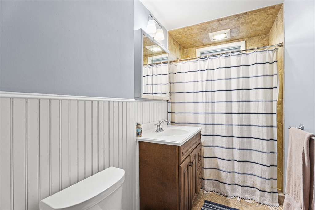 15 Sturgis Street Woburn, MA 01801 - Photo 34 of 38 a bathroom with a sink a toilet and shower curtain