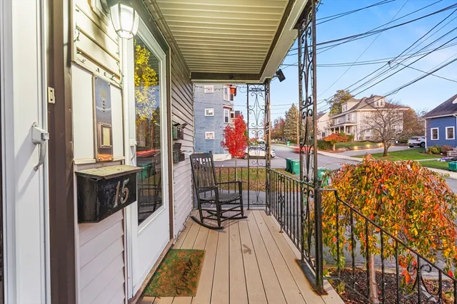 a kitchen with granite countertop a stove a sink and white cabinets with wooden floor next to windows