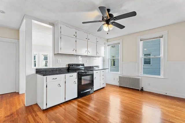 a kitchen with granite countertop white cabinets and stainless steel appliances
