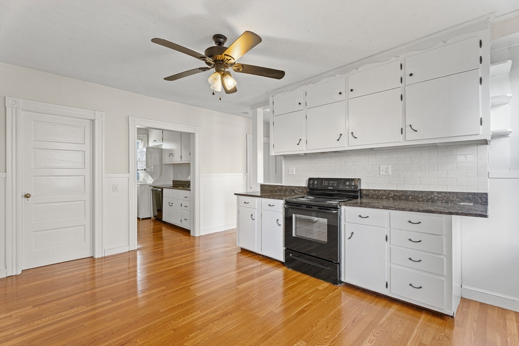 15 Sturgis Street Woburn, MA 01801 - Photo 7 of 38 a kitchen with granite countertop white cabinets and stainless steel appliances