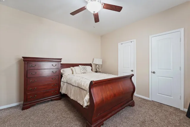 a bedroom with a bed and a ceiling fan