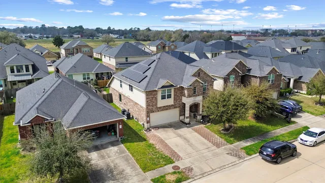 an aerial view of residential houses with outdoor space and parking