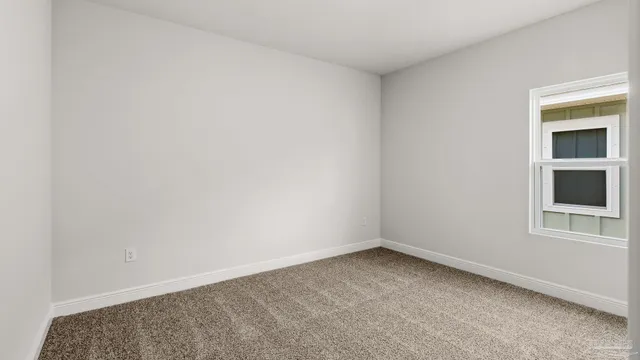 a front view of house with yard and trees in the background