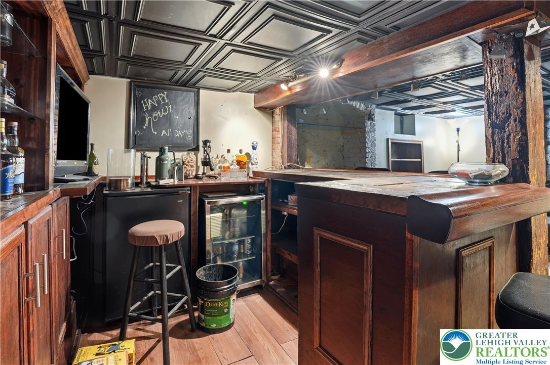 2014 Linden Street Bethlehem, PA 18017 - Photo 53 of 85 A well-appointed home bar, complete with dark wood cabinetry and a classic tin ceiling, offers an ideal entertainment space.