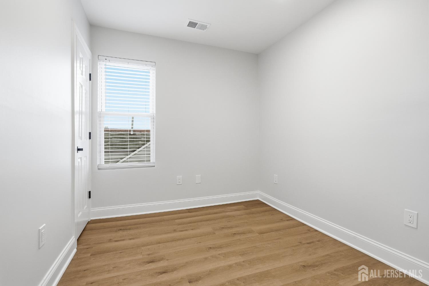 115 Remsen Avenue New Brunswick, NJ 08901 - Photo 33 of 38 a view of an empty room with wooden floor and a window