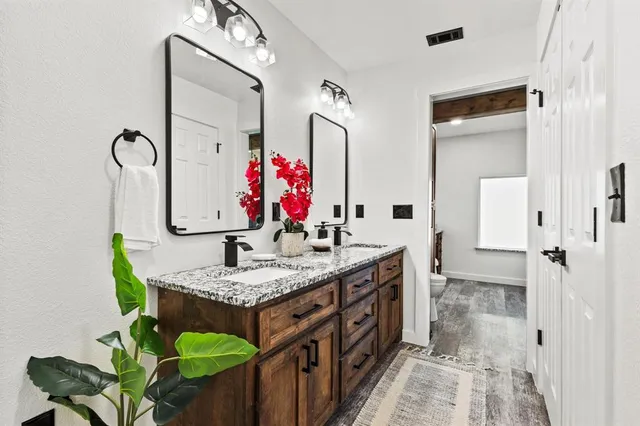 a bathroom with a granite countertop sink and a mirror